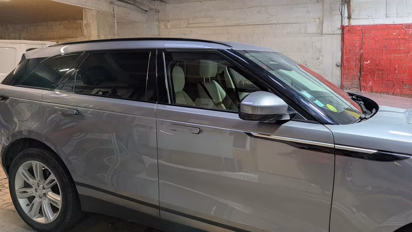 Flanc d'un Range Rover Velar gris dont Autovring a teinté les vitres arrière, les vitres avant restant claires